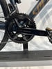 Detail der Shimano 105 Kurbel und des Umwerfers auf dunkelblauem Rahmen.