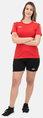 Eine Frau in einem roten T-Shirt und schwarzen Shorts mit verschränkten Armen. Eine Frau in einem roten T-Shirt und schwarzen Shorts mit verschränkten Armen.