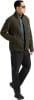 Ein Mann in einer dunkelgrünen Fleecejacke und schwarzer Hose mit blauer Sonnenbrille.