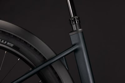 Detail eines hinteren Schutzblechs und eines Sitzrohrs eines E-Bikes vor dunklem Hintergrund.