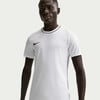 Ein Mann in einem weißen Nike-T-Shirt mit schwarzer Paspel und Logo auf der Brust.