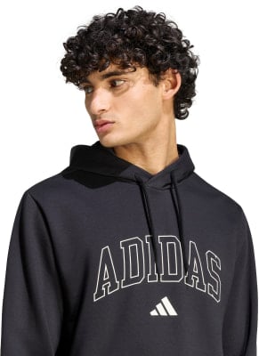 Ein Mann in einem schwarzen Kapuzenpullover mit Adidas-Logo auf der Brust. Ein Mann in einem schwarzen Kapuzenpullover mit Adidas-Logo auf der Brust.