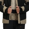 Eine geschlossene Jacke mit beige und schwarzen Einsätzen und zwei Händen darin.