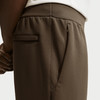 Detail einer Hose mit Tasche und Reißverschluss, braune Farbe.