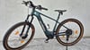 Grünes KTM Mountain E-Bike mit braunen Reifen und Federgabel.