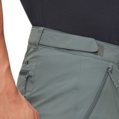 Detail einer Hose mit Reißverschlusstasche und Markenlogo.
