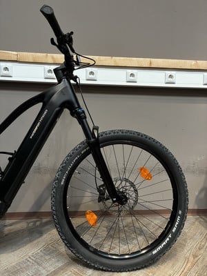 Vorderseite eines schwarzen E-Bikes mit Federung und der Aufschrift Intersport Pötscher. Vorderseite eines schwarzen E-Bikes mit Federung und der Aufschrift Intersport Pötscher.