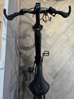 Ein schwarzes E-Bike mit Display und ergonomischem Lenker auf Holzboden. Ein schwarzes E-Bike mit Display und ergonomischem Lenker auf Holzboden.