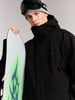 Ein Mann in einer Skijacke hält ein Snowboard mit grünem Flammenmuster.