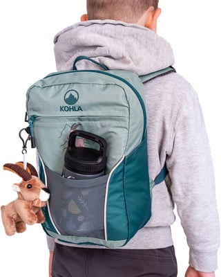 Ein Kind mit einem Rucksack und einer Plüschziege auf dem Rücken.