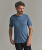 Ein Mann in einem blauen T-Shirt mit Helm-Logo und schwarzer Hose.
