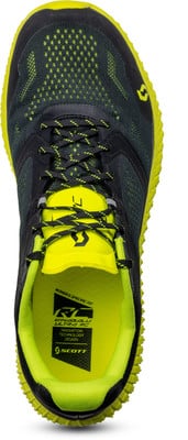 Grüner Scott Laufschuh mit schwarzen Elementen und Schnürsenkeln. Grüner Scott Laufschuh mit schwarzen Elementen und Schnürsenkeln.