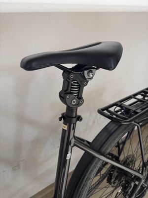 Schwarze Federstütze mit schwarzem Sattel an einem Fahrrad. Schwarze Federstütze mit schwarzem Sattel an einem Fahrrad.