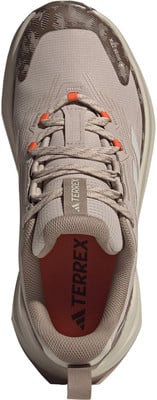 Oberansicht eines beigen Adidas Terrex Laufschuhs mit orangefarbenen Akzenten. Oberansicht eines beigen Adidas Terrex Laufschuhs mit orangefarbenen Akzenten.