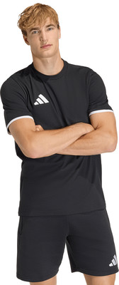 Ein Mann in einem schwarzen T-Shirt und Shorts mit Adidas-Logo steht mit verschränkten Armen. Ein Mann in einem schwarzen T-Shirt und Shorts mit Adidas-Logo steht mit verschränkten Armen.