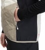 Detail einer Jacke mit beige und schwarzen Einsätzen, Hand in der Tasche.