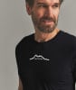 Mann in schwarzem T-Shirt mit Berglogo und Schriftzug ORTOVOX.