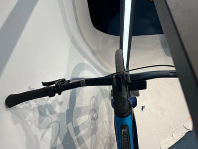 Detail des Lenkers eines blauen E-Bikes mit schwarzen Griffen und Bremshebel. Detail des Lenkers eines blauen E-Bikes mit schwarzen Griffen und Bremshebel.