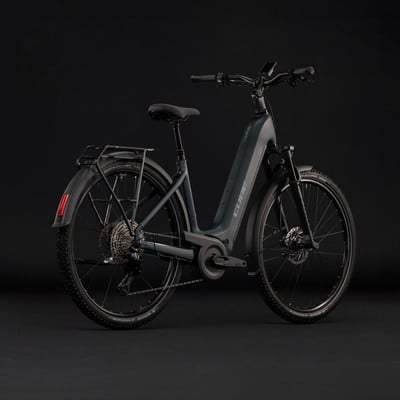 Graues Cube E-Bike mit Gepäckträger und Schutzblechen vor schwarzem Hintergrund. Graues Cube E-Bike mit Gepäckträger und Schutzblechen vor schwarzem Hintergrund.