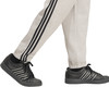 Graue Jogginghose mit schwarzen Streifen und schwarzen Adidas-Sneakern