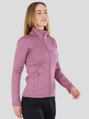 Egy nő rózsaszín, cipzáros, zsebes polárkabátban szürke háttér előtt. Egy nő rózsaszín, cipzáros, zsebes polárkabátban szürke háttér előtt.