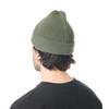 Ein Mann von hinten trägt eine grüne Strickmütze und ein schwarzes T-Shirt.