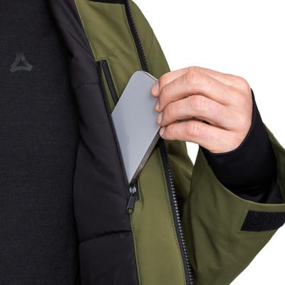Ein Mann steckt ein Handy in die Innentasche einer grünen Jacke. Ein Mann steckt ein Handy in die Innentasche einer grünen Jacke.