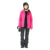 Frau in pinker Jacke und schwarzer Hose beim Skifahren mit Helm.