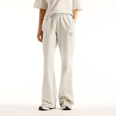 Frau in grauer Jogginghose mit Logo und silbernen Turnschuhen. Frau in grauer Jogginghose mit Logo und silbernen Turnschuhen.