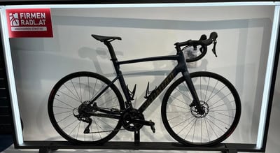 Dunkelblaues Specialized Rennrad auf einem Ständer mit Firmenlogo. Dunkelblaues Specialized Rennrad auf einem Ständer mit Firmenlogo.
