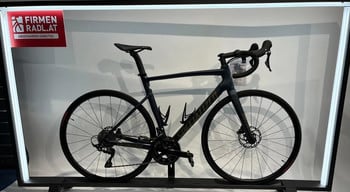 Dunkelblaues Specialized Rennrad auf einem Ständer mit Firmenlogo.
