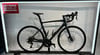 Dunkelblaues Specialized Rennrad auf einem Ständer mit Firmenlogo.