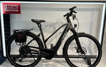 Schwarzes KTM E-Bike mit Gepäckträger und Trelock Tasche am Hinterrad.