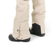 Beige Hose mit schwarzen Stiefeln und Druckknopf-Schlitz.