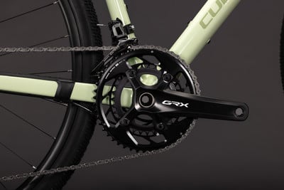 Nahaufnahme der Fahrradkurbel und Kette mit GRX-Logo. Nahaufnahme der Fahrradkurbel und Kette mit GRX-Logo.