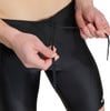 Detail der Hände, die die Kordel einer schwarzen Badehose festziehen.