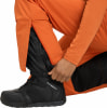 Detail eines Mannes, der seine Skihosenbein an seinem Schuh anpasst.