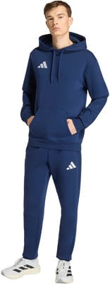 Mann im dunkelblauen Adidas-Anzug mit Logo auf Brust und Bein. Mann im dunkelblauen Adidas-Anzug mit Logo auf Brust und Bein.