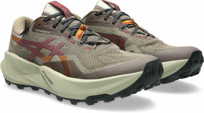 Braune Trailrunning-Schuhe mit markanter Sohle und roten Details.