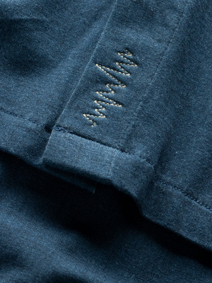 Blauer Stoff mit feiner Wellenlinien-Stickerei. Blauer Stoff mit feiner Wellenlinien-Stickerei.