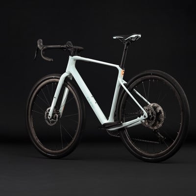 Hellblaues Gravelbike mit schwarzen Rädern und Rahmendetails. Hellblaues Gravelbike mit schwarzen Rädern und Rahmendetails.