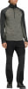 Ein Mann in Outdoor-Kleidung mit gestreiftem Pullover und schwarzer Hose.