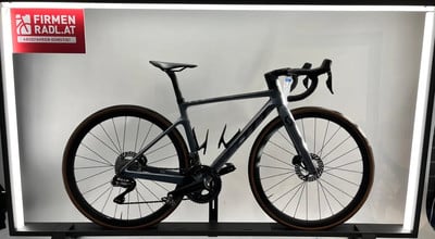 Ein graues Scott Rennrad mit braunen Felgen auf einem Ständer. Ein graues Scott Rennrad mit braunen Felgen auf einem Ständer.