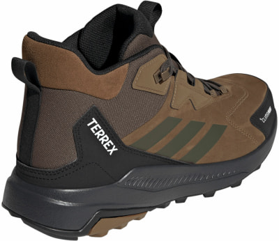 Braune Adidas Terrex Outdoor-Schuhe mit schwarzen Details und grünen Streifen. Braune Adidas Terrex Outdoor-Schuhe mit schwarzen Details und grünen Streifen.