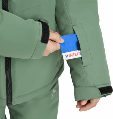Eine Person steckt eine blaue Karte in die Tasche einer grünen Jacke. Eine Person steckt eine blaue Karte in die Tasche einer grünen Jacke.