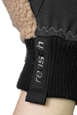 Detail eines Handschuhs mit Reusch-Logo und beigem Fellbesatz. Detail eines Handschuhs mit Reusch-Logo und beigem Fellbesatz.