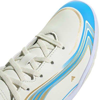 Detail eines weißen Fußballschuhs mit blauen und goldenen Streifen. Detail eines weißen Fußballschuhs mit blauen und goldenen Streifen.