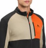 Ein Mann trägt eine beige, schwarze und orangefarbene Jacke mit McKinley-Logo.