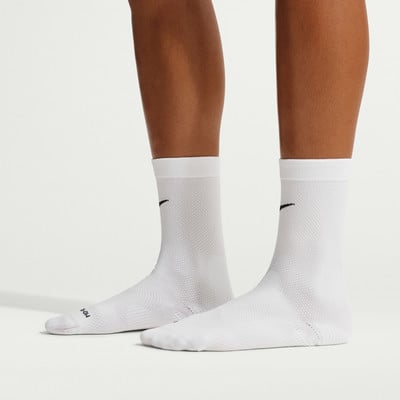 Zwei Beine in weißen Nike-Socken mit schwarzem Logo an jedem Bein.