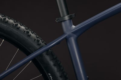Detail des Rahmens und Rades eines dunkelblauen Mountainbikes.
